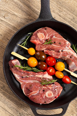 Raw lamb chops with tomato and rosemary herb ready to cook