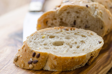 bread with seeds on a wooden board and knife