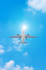 Passenger airplane flying in the blue sky with sunshine