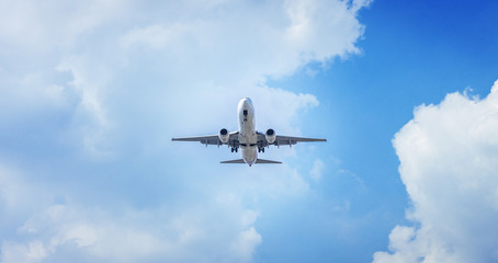 Naklejka na ściany i meble Passenger airplane flying in the blue sky