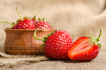 Ripe Strawberry in a wooden Bowl on burlap background