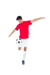Fototapeta na wymiar Football player in red kicking ball