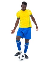 Football player in yellow kicking ball