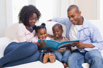 Happy family on the couch reading storybook