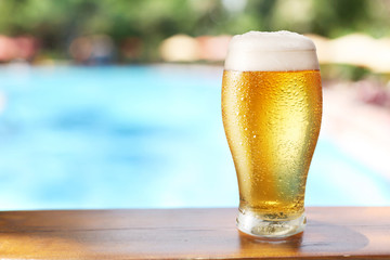 Cold beer glass on the bar table at the open-air cafe.