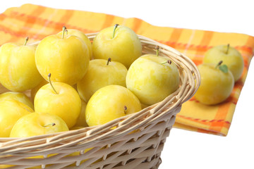 Yellow plums in wicker basket