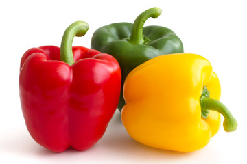 Red, yellow, green peppers on white background.