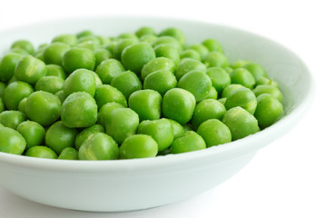 Detail of fresh garden peas in a white ceramic bowl.