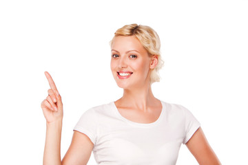 Fototapeta premium smiling woman with blank white t-shirt pointing up at copy space