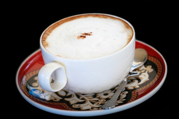A cup of cappuccino on black background