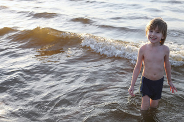 Smiling Caucasian boy coming out of the sea
