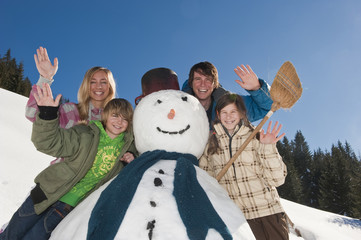 Familie, die durch Schneemann, winken , Portrait