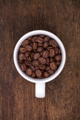cup of coffee beans on the brown wooden background