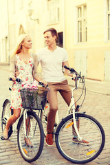Fototapeta premium smiling couple with bicycles in the city