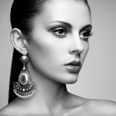 Portrait of beautiful young woman with earring. Jewelry and acce