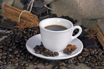 Cup of coffee with coffee beans, chocolate and spices