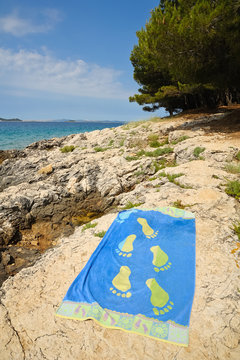 Badetuch liegt am Felsstrand an der K&uuml;ste