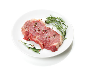 Raw sirloin steak with rosemary and spices on plate