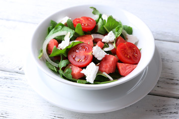 Salad with watermelon, onion, arugula and spinach leaves