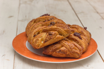 Sweet pecan bun on an orange plate
