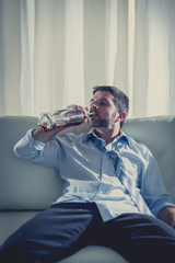 drunk Businessman drinking whiskey wasted on couch at home