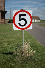 A five miles per hour sign on a grass verge