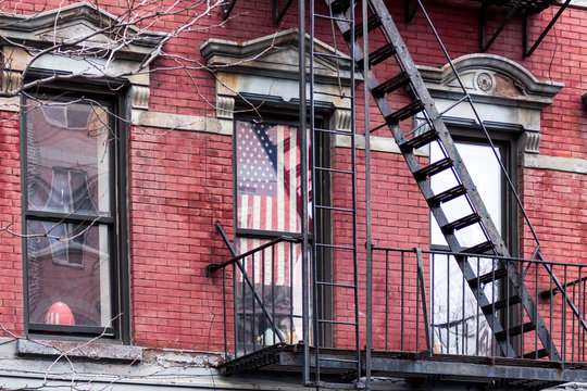 Fire steps in New York and USA flag in window.