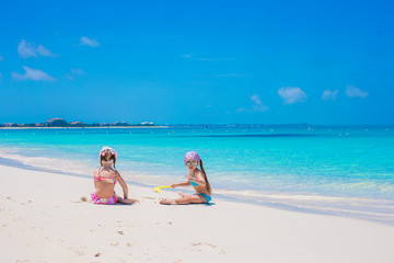 Little cute girls on white beach during vacation