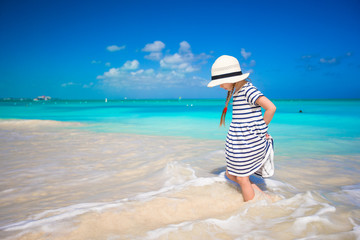 Fototapeta na wymiar Adorable little girl runing in shallow water at exotic beach
