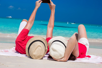 Happy couple taking a photo themselves on tropical beach