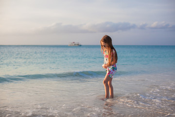 Adorable little girl walking at white tropical beach