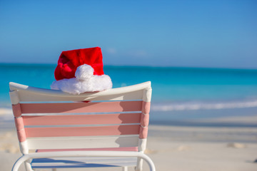 Close up Santa hat on chair longue at tropical beach