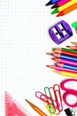 Colorful school supplies corner border over graphing paper