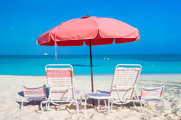 Cute umbrellas and sunbeds at tropical beach