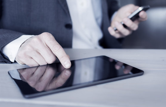 Businessman using tablet pc and smartphone
