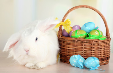 White cute rabbit and Easter eggs in basket