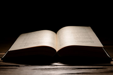 Old book on table on black background