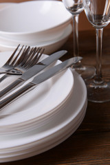 Set of white dishes on table on brown background
