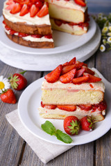 Delicious biscuit cake with strawberries on table close-up