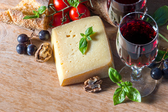 cheese with red wine, walnuts, and grapes. food background