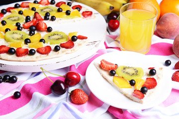 Sweet pizza with fruits on table close-up