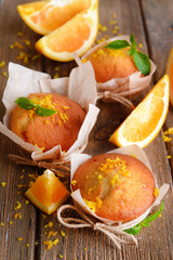 Tasty cupcakes with orange on table close-up