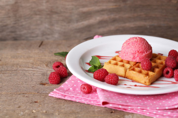 Tasty belgian waffles with ice cream on wooden table