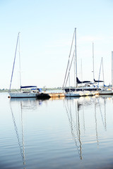 Fototapeta na wymiar Yachts standing at lake pier