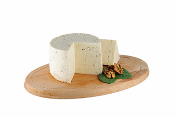 Cheese with walnuts on wooden cutting board