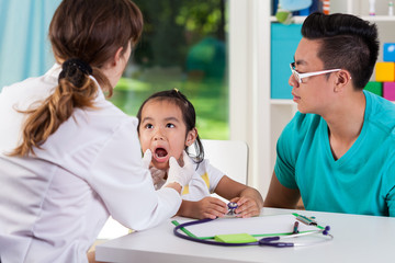 Asian girl with dad at pediatrician