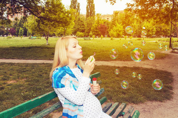 Pregnant park blowing bubbles