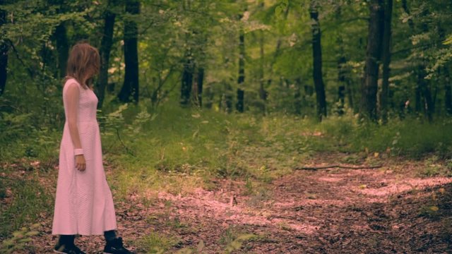 Horror movie scene with a girl dressed in white in the forest