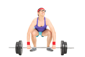 Nerdy guy struggling to lift a barbell