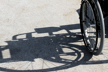 Fototapeta na wymiar shadow of the wheelchair and the detail of the tyre